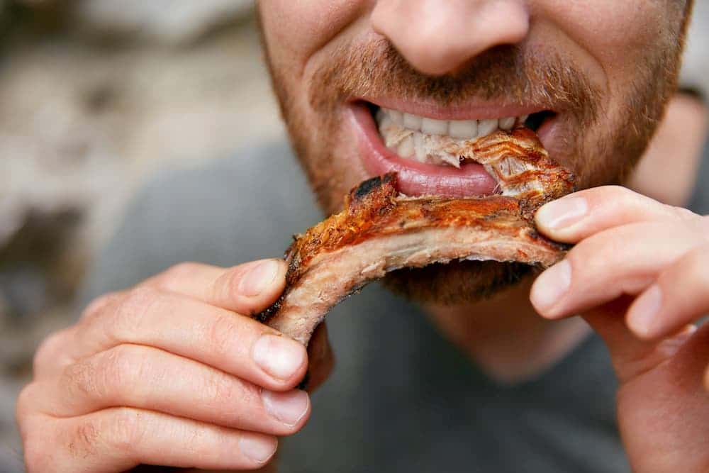 man eating ribs
